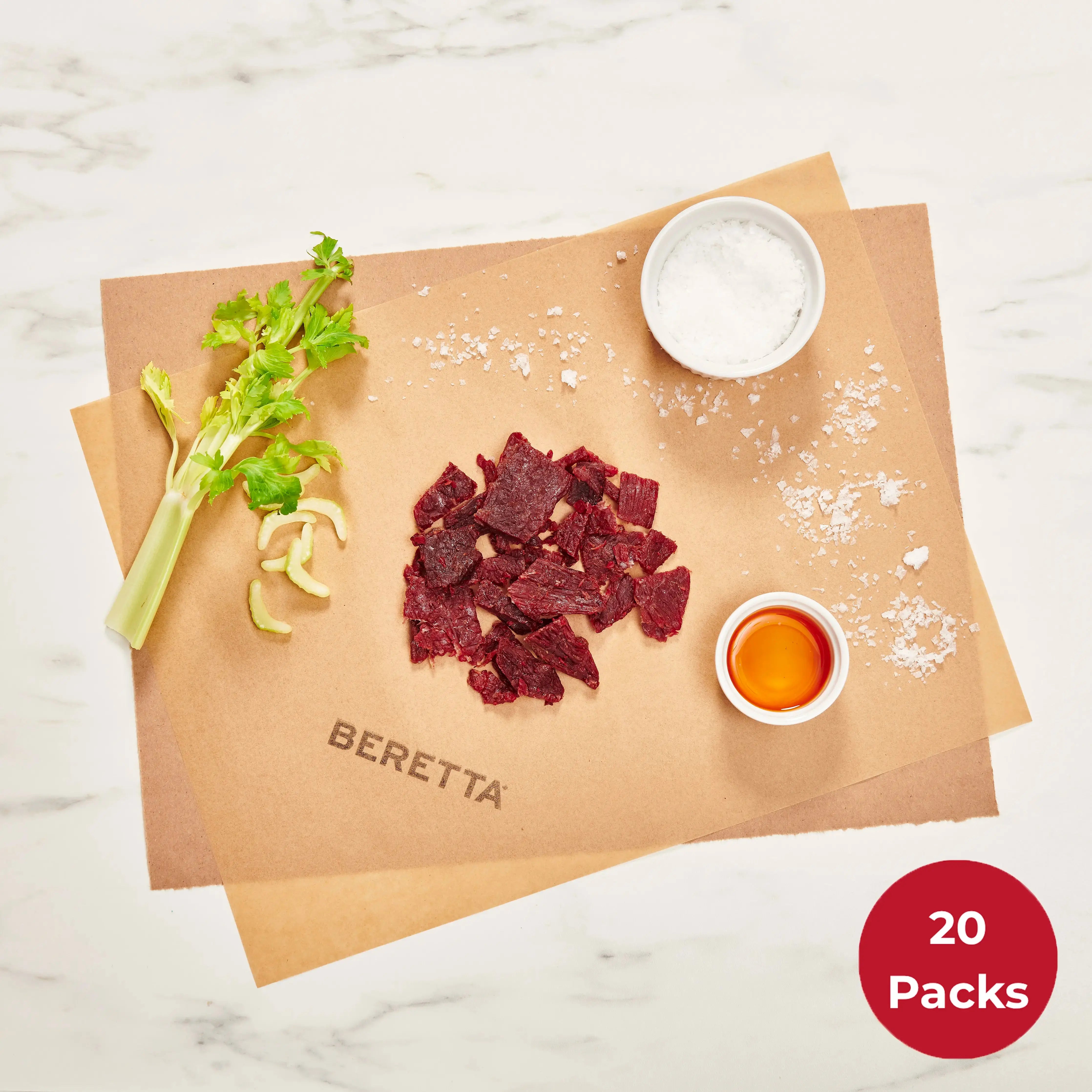 Portioned packages of Beretta Original Beef Jerky on a paper, with ingredients like celery and salt visible.