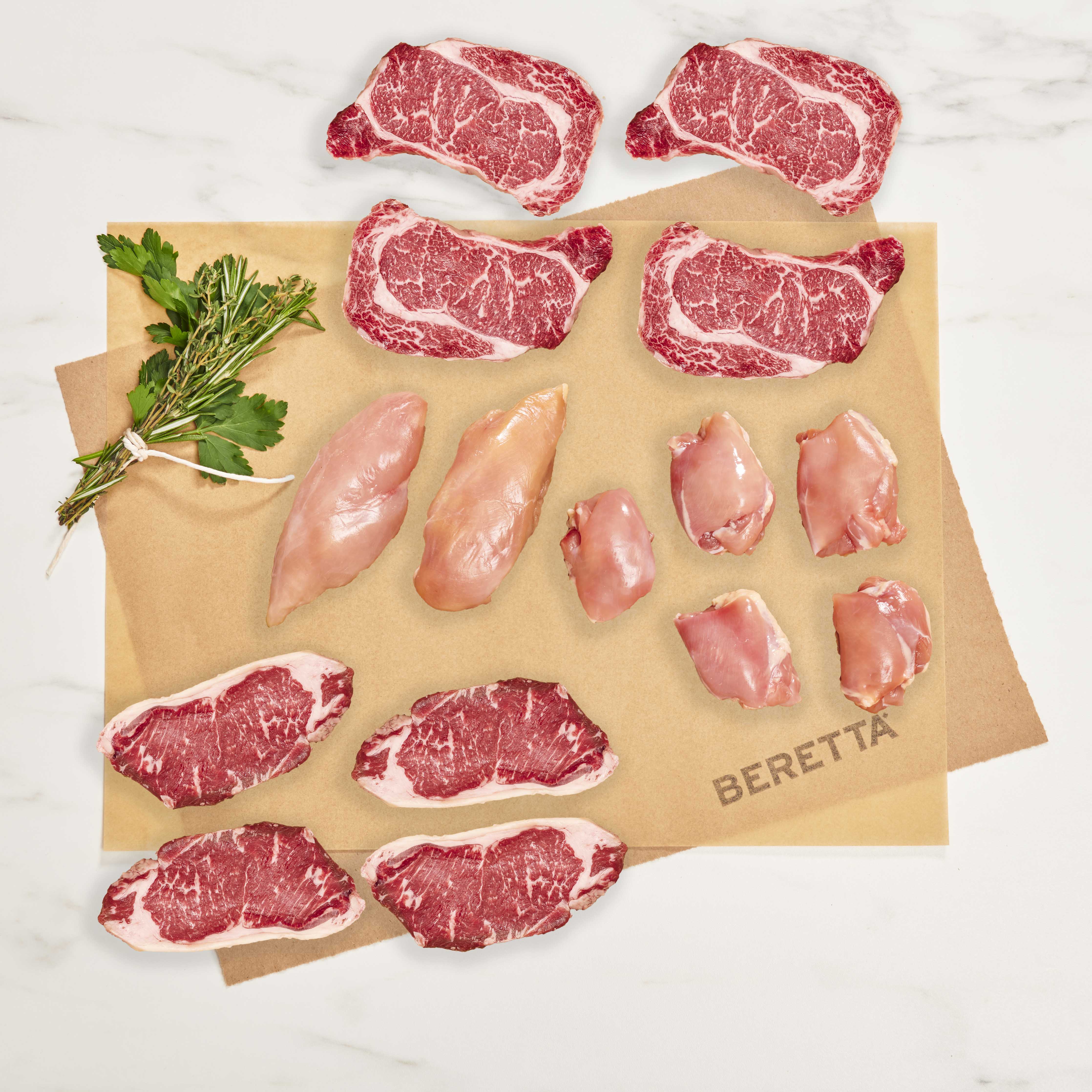 Raw meat cuts on a Beretta branded cutting board with fresh herbs.