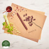 A top-down styled flat lay of a Beretta beef jerky stick on kraft paper sheets with seasoning, celery, and a small bowl of red sauce on a white marble surface. A green badge in the corner reads '100% Canadian Grass Only Beef'.