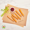 A pack of six chicken hot dogs on a beige paper against a white marble background, accompanied by celery sticks and a small bowl of spices. The brand 'BERETTA' is visible on the paper.